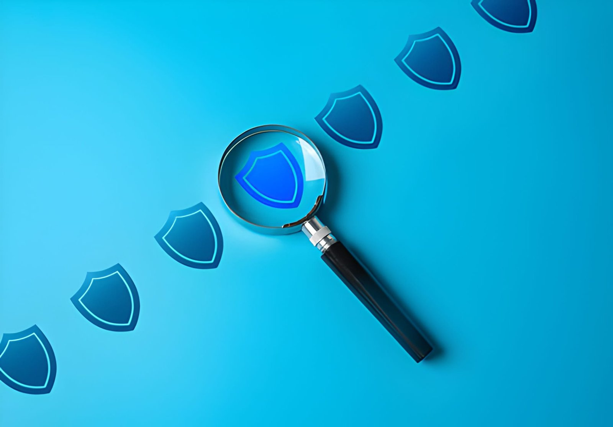 Magnifying glass analyzing digital security shield icons