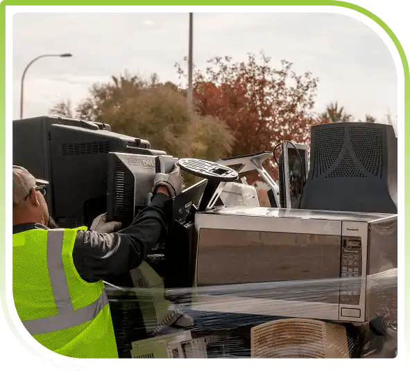 Worker collecting computers and storage devices for safe and certified hard drive disposal.