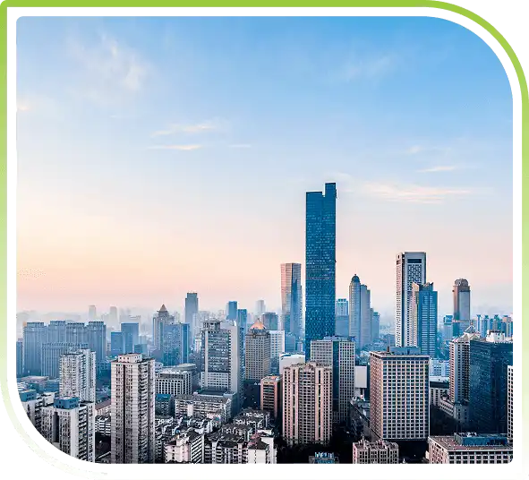 Wide view of a modern city skyline at sunset.