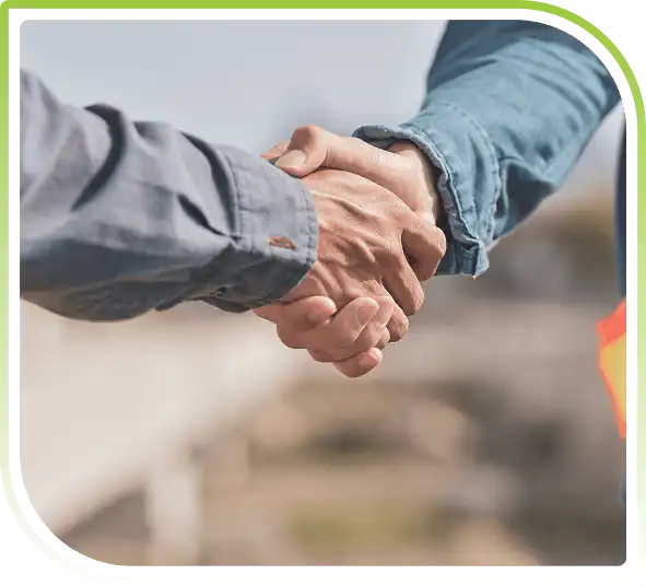 Two people in denim and grey shirts shaking hands.