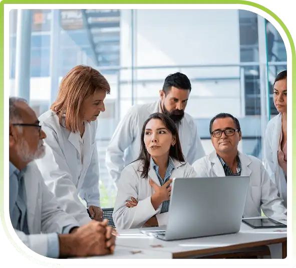 Healthcare professionals collaborating and reviewing information on a laptop