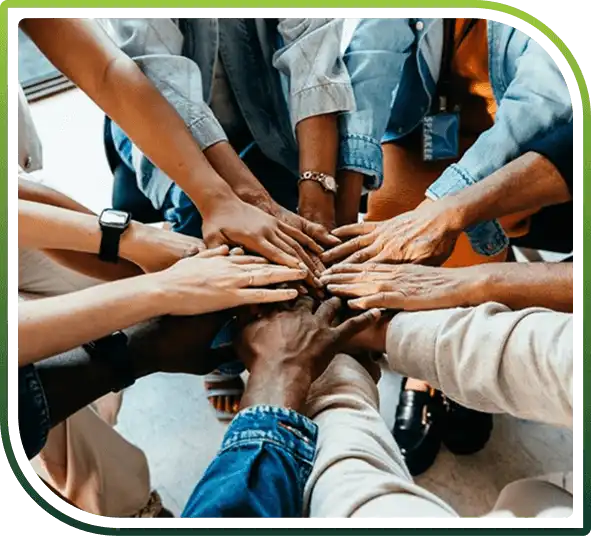 Diverse group of people placing their hands together to represent teamwork and collaboration