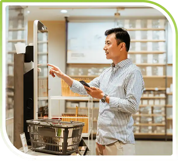 Retail customer using a self-service kiosk and mobile device inside a modern store