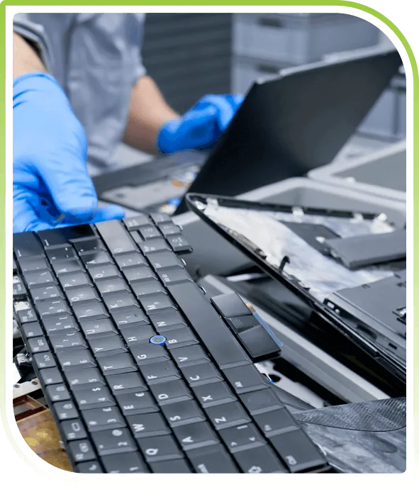 Technician disassembling a laptop keyboard and components, representing secure IT asset disposal and compliant ITAD services.