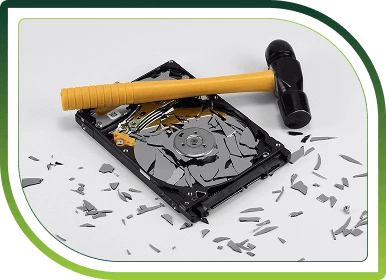 Shattered hard drive struck with a hammer, representing secure data destruction and compliant IT asset recycling services.