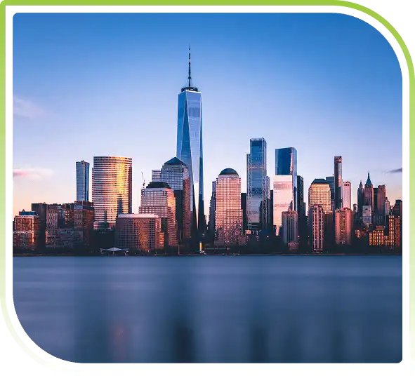 New Jersey waterfront view overlooking the Manhattan skyline with modern high-rise buildings reflected across calm water at sunset.