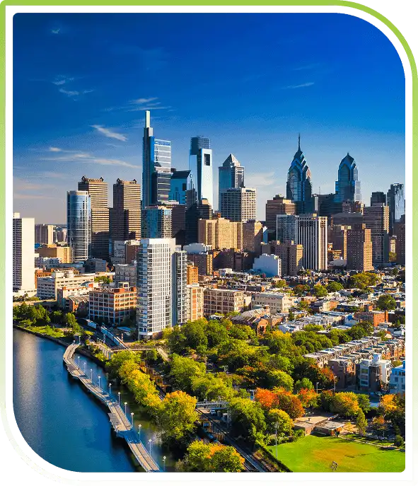 Pennsylvania city skyline showcasing tall high-rise buildings, dense urban streets, and a vibrant downtown atmosphere at dusk.