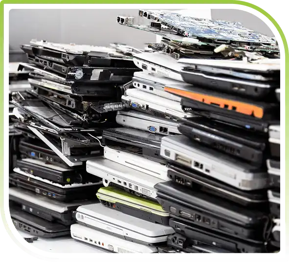Stack of discarded laptops and electronic devices prepared for secure recycling, representing responsible laptop disposal services.