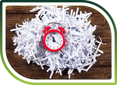 Clock with shredded paper illustrating fast, reliable paper shredding services and timely secure document destruction.