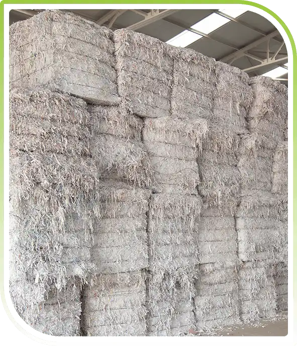Large piles of shredded paper stored in warehouse showcasing secure paper shredding and responsible recycling processes.